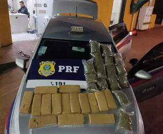 Tabletes e sacos de maconha encontrados dentro do veículo. (Foto: PRF)