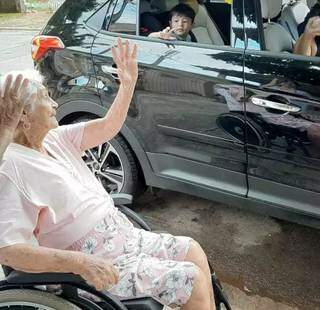 Durante o drive-thru, matriarca Eulália cumprimentava as pessoas; no clique, bisnetinho acena de dentro do carro (Foto: Arquivo Pessoal)