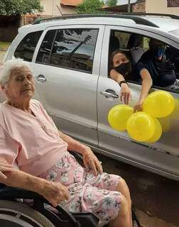 Eulália posa para foto ao lado de um carro com seus familiares; balão de bexiga e bolinho não faltaram (Foto: Arquivo Pessoal)