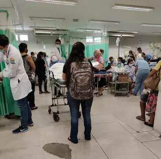 Pronto-socorro da Santa Casa de Campo Grande estava tão lotado na quinta passada que pacientes eram atendidos sentados e acompanhantes ficaram em pé (Foto: Direto das Ruas)