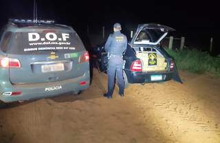 Policial do DOF parado ao lado de Astra com maconha (Foto: Divulgação)