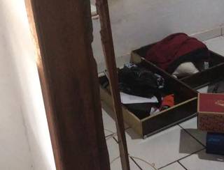 Estrado causado na porta após o arrombamento e as gavetas do guarda-roupas no chão do quarto. (Foto: Arquivo pessoal)