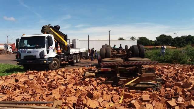 Caminh&atilde;o carregado de tijolos tomba e motorista fica preso &agrave;s ferragens
