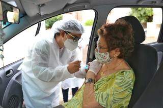 Idosa sendo vacinada em drive-thru da Capital. (Foto: Paulo Francis)