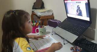 Valentina participa das aulas on-line interagindo com as professoras em frente do PC (Foto: Arquivo Pessoal)