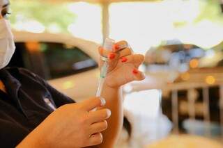 Técnica de enfermagem colhe dose de vacina para aplicação. (Foto: Kísie Ainoã)
