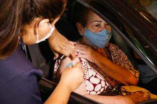 Mulher é vacinada em drive-thru do Parque Ayrton Sena. (Foto: Henrique Kawaminami)