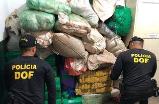 Policiais empilham fardos de maconha apreendidos em Itaquiraí (Foto: Divulgação)