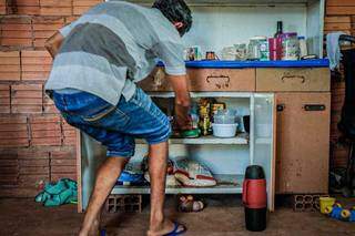 Morador da Favela do Linhão, em Campo Grande, conta alimentos no armário, escassez ampliada em época de pandemia (Foto/Arquivo: Henrique Kawaminami)