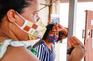 Renata com a mãe Isabel à espera de vacina. As duas já haviam ido até o posto do Coronel Antonino também. (Foto: Henrique Kawaminami)