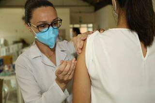 Profissional de saúde aplica vacina em pessoa do público-alvo (Foto: Kísie Ainoã)