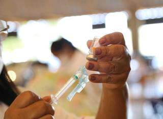 Profissional da saúde com uma das vacinas contra a covid-19 em mãos. (Foto: Kísie Ainoã) 