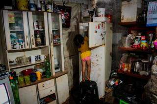 A pequena Sofia busca o que comer dentro da galedeira vazia. (Foto: Marcos Maluf)