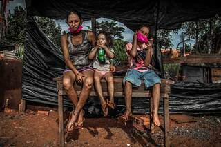 Hellen e as filhas Sofia, 3 anos e Vitória, 7 anos, esperam em frente ao barraco onde moram ajuda para ter o que comer. (Foto: Marcos Maluf)