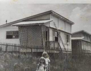 Casa de madeira que era desmontada. Na foto está Katia ao lado de sua boneca. (Foto: Arquivo Pessoal/Katia Kintshcner)