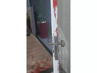 Porta e entrada da casa sujas de sangue; situação assustou moradores (Foto: Reprodução/Facebook)