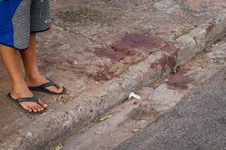 Criança, de 9 anos, ao lado de manchas de sangue provocadas por ataque (Foto: Henrique Kawaminami)