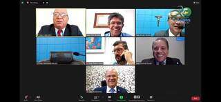 Bom humor durante sessão: deputados riem de histórias de José Almi, de óculos e gravata vermelha à esquerda. (Foto: Reprodução de vídeo)