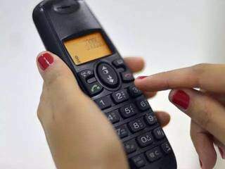 Mulher utiliza telefone fixo para ligação (Foto: Arquivo/Campo Grande News)