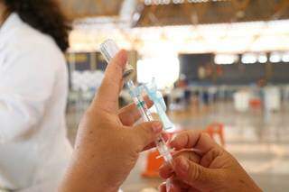 Profissional da saúde segurando vacina contra a covid-19, única forma de combater a doença. (Foto: Kísie Ainoã) 