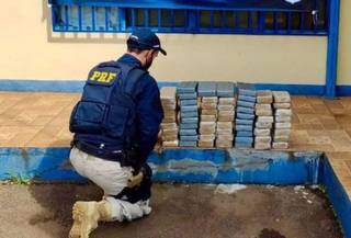 Policial de frente com os tabletes da droga. (Foto: Dourados News) 