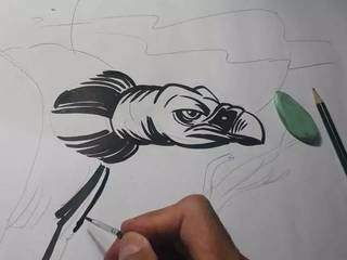 Registro do autor desenhando os traços de um urubu, ave que marca a obra (Foto: Arquivo Pessoal)