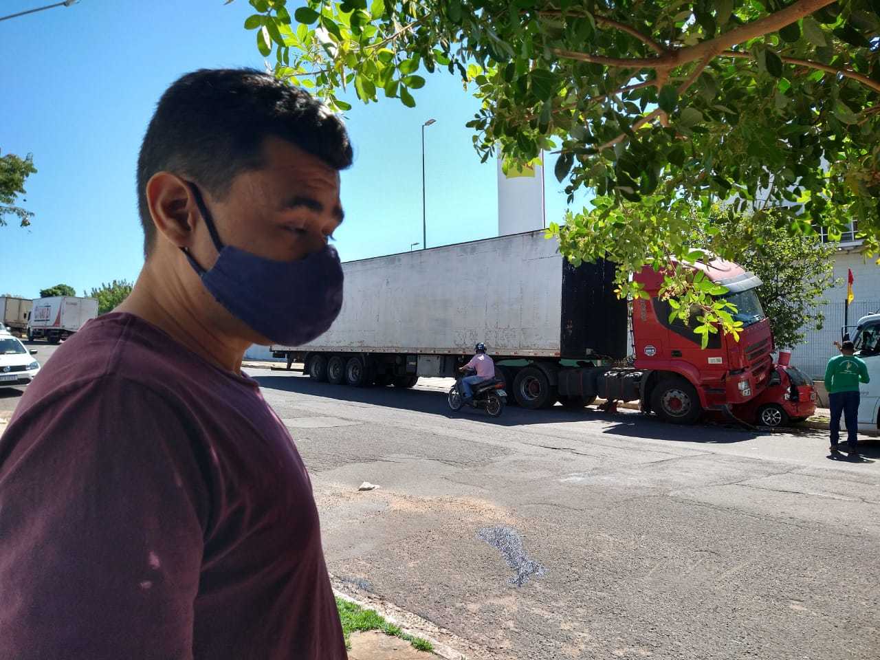 Dono do Corsa do outro lado da rua onde ocorreu o acidente, ao fundo o caminhão. (Foto: Mariana Rodrigues)