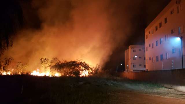 Terreno pega fogo e chamas se aproximam de condom&iacute;nio 