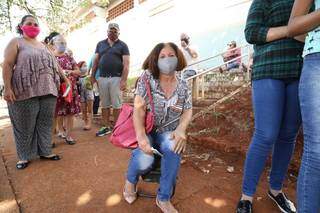 Com fila virando a quadra, jeito &eacute; levar cadeira e tentar se proteger do sol