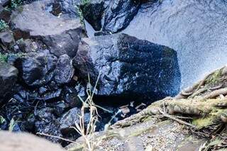 No detalhe da imagem, corpo da vítima entre as pedras do Inferninho. (Foto: Henrique Kawaminami)