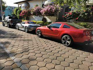 Porsche (veículo cinza) e Mustang (vermelho) foram apreendidos hoje em operação da Polícia Federal. (Foto: Weber Reis/Folha MS)