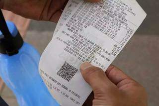 Consumidor segura nota fiscal solicitada depois de fazer compra (Foto: Kísie Ainoã)