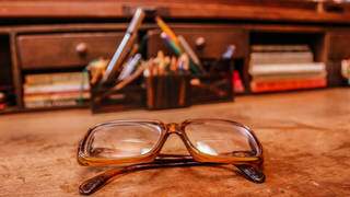 Sobre a escrivaninha, os óculos que Manoel usava para enxergar as insignifâncias. (Foto: Marithê do Céu)
