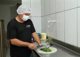 Empresário e comerciante Calixto Couto preparando os acompanhamentos da feijoada. (Foto: Kísie Ainoã)