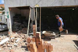 José Carlos consertando o muro de sua borracharia. (Foto: Paulo Francis)