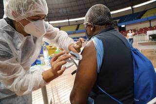 Pessoa com comorbidade recebe vacina no braço de profissional de saúde no Guanandizão (Foto: Kísie Ainoã/Arquivo)