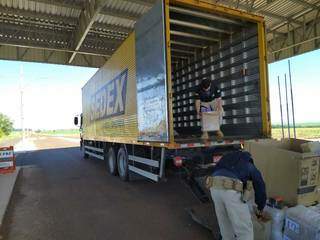Policiais rodoviários retiram caixas de contrabando de caminhão dos Correios (Foto: Divulgação)