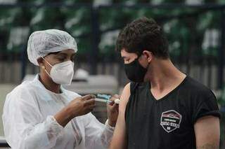 Profissional de saúde aplica dose de vacina em servidor de força de segurança na Capital (Foto: Marcos Maluf/Arquivo)