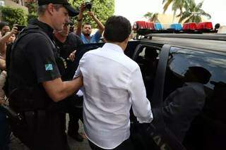 Olarte é conduzido por policial durante prisão em 2016. (Foto: Arquivo/Campo Grande News)