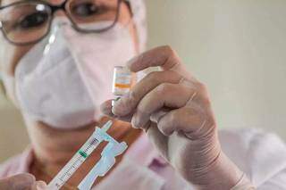 Profissional de saúde prepara vacina para imunizar pessoa na Capital (Foto: Silas Lima/Arquivo)