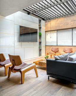Mobiliário de design contrasta com elementos em preto e cinza da decoração. (Foto: Janaina Lott)