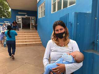 Daiane Ferreira, de 31 anos, com o filho de um mês no colo em frente ao CRS Tiradentes. (Foto: Aletheya Alves)