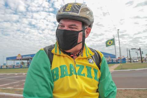Fãs enfrentam vento em espera solitária pelo desembarque de Bolsonaro