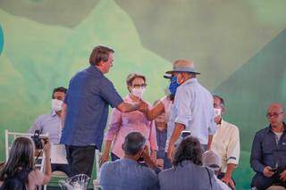 Presidente Jair Bolsonaro à esquerda, ao lado da ministra da Agricultura Tereza Cristina, apertando a mão de produtores. (Foto: Henrique Kawaminami)