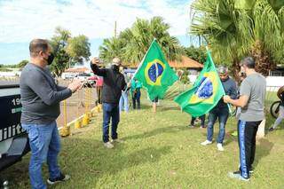 Apoiadores com bandeiras fazem selfie antes do desembarque. (Foto: Kisie Ainoã)