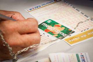 Apostador marcando as dezenas da sorte em lotérica da Capital. (Foto: Henrique Kawaminami)