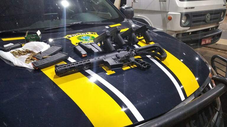 Os fuzis, pistolas e munições encontradas no veículo. (Foto: Divulgação/PRF)