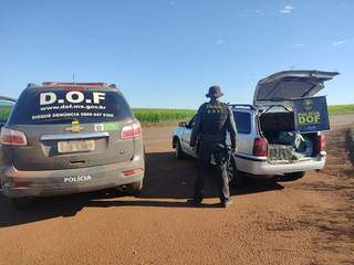 Policial do DOF ao lado da Parati onde as drogas estavam sendo transportadas. (Foto: DOF) 