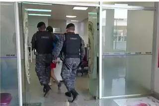 Policiais chegam com um dos presos na Operação &#34;Araceli&#34; em delegacia da Capital (Foto: Aletheya Alves)