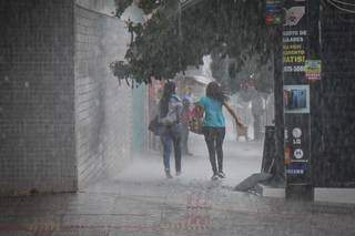 Mulheres na Capital correndo para se esconder da chuva. (Foto: Henrique Kawaminami)